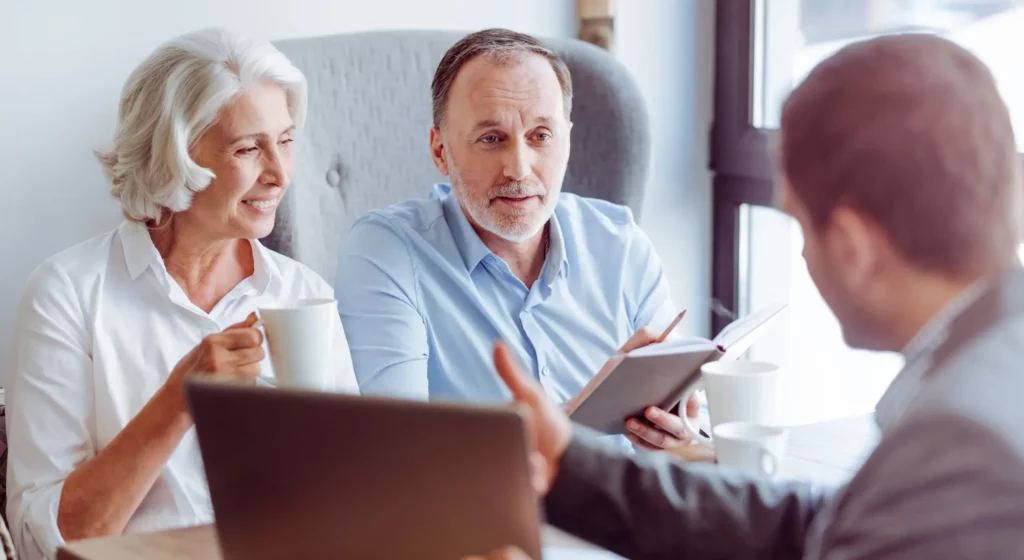 Couple de seniors en rendez-vous pour préparer leurs obsèques ou contrat de prévoyance.
